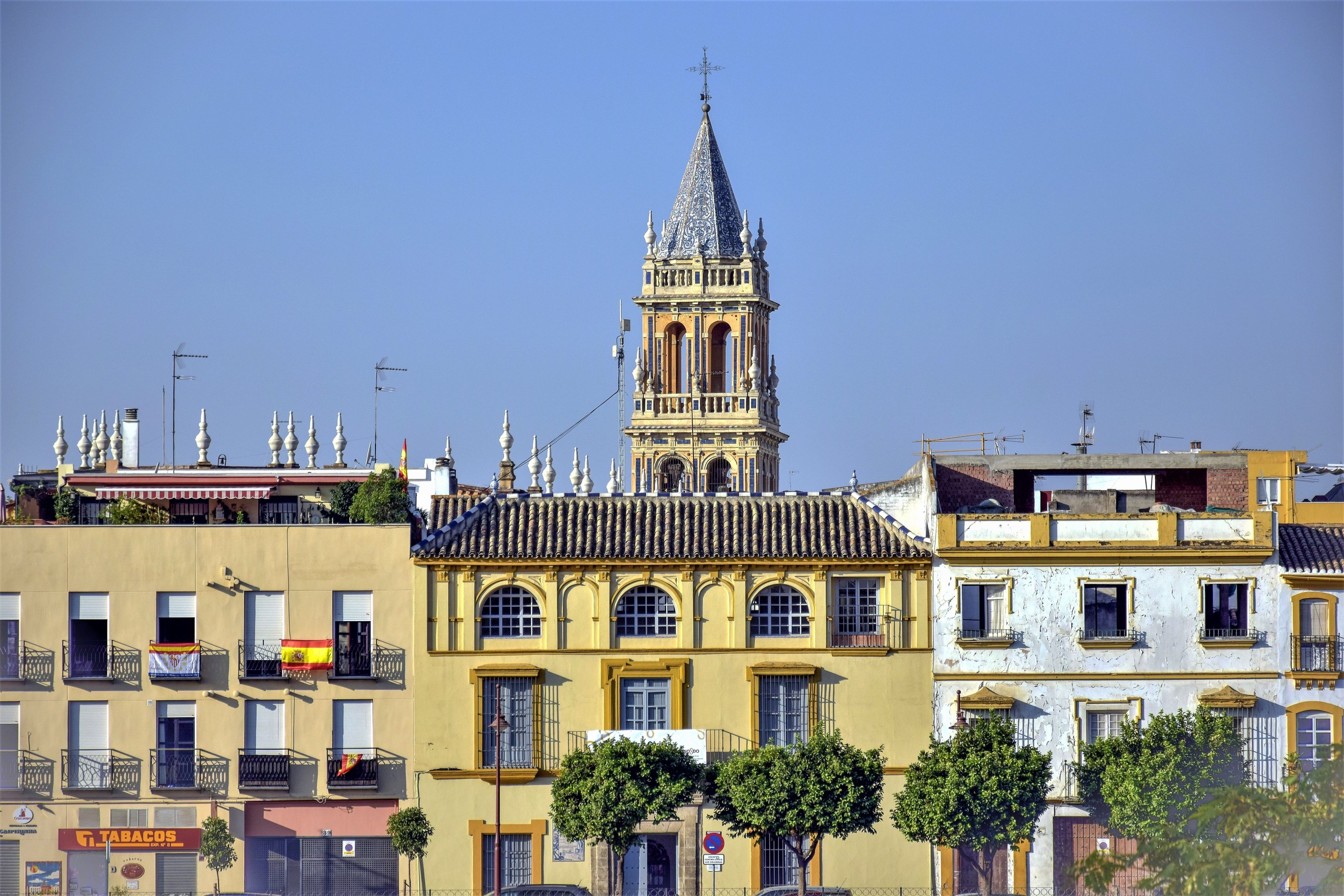 Colorful buildings with a church tower in Seville, Spain.