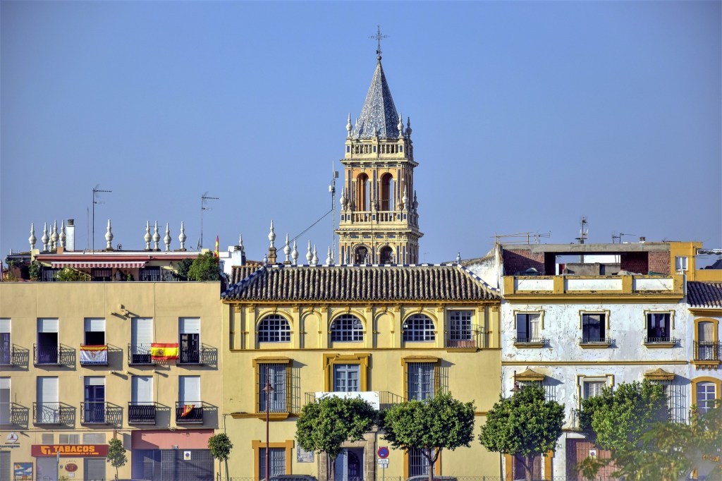 Colorful buildings with a church tower in Seville, Spain.