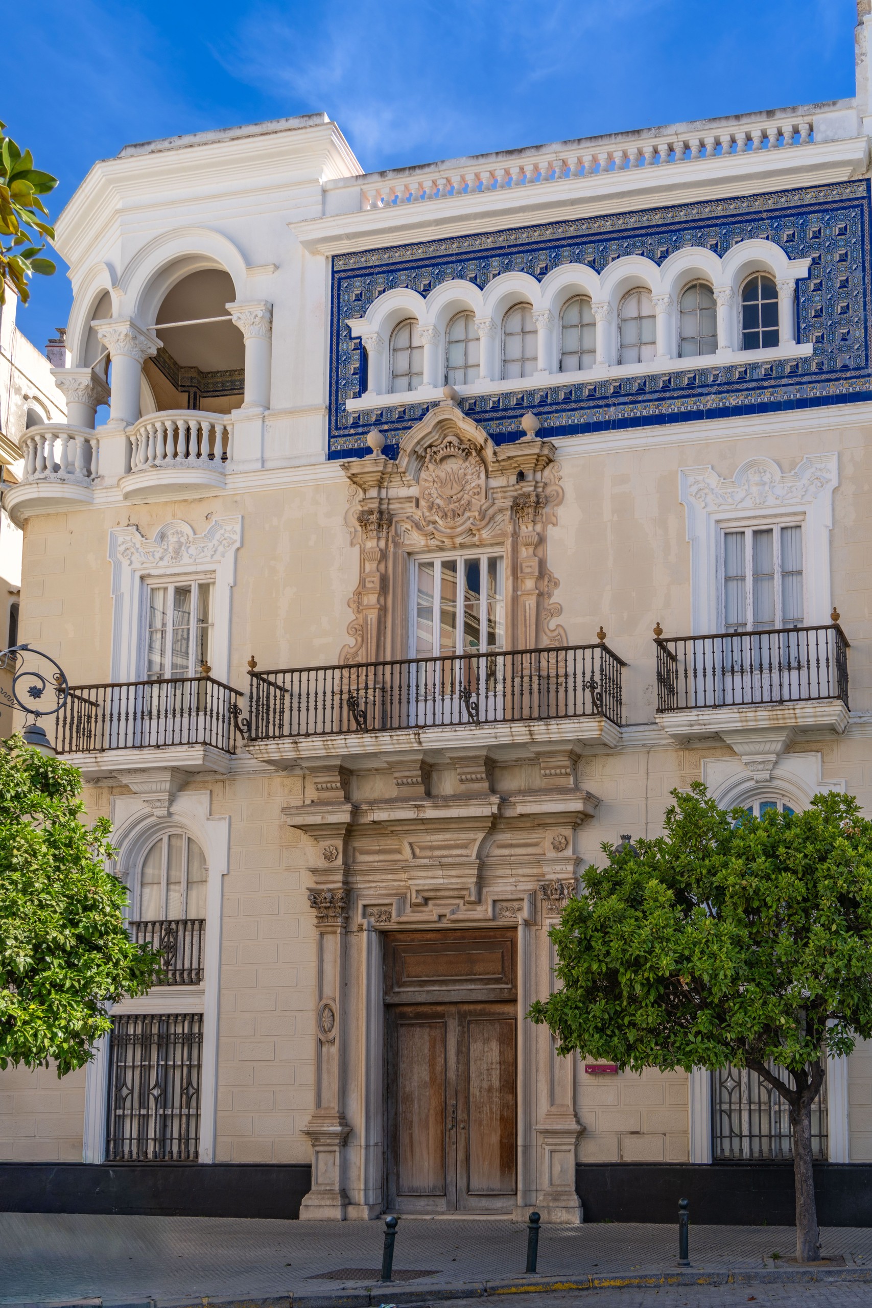 Ornate building facade with arches, balconies, and blue tile detail.