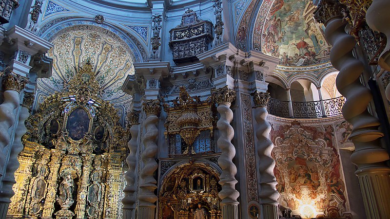 Ornate baroque church interior with elaborate carvings and murals.