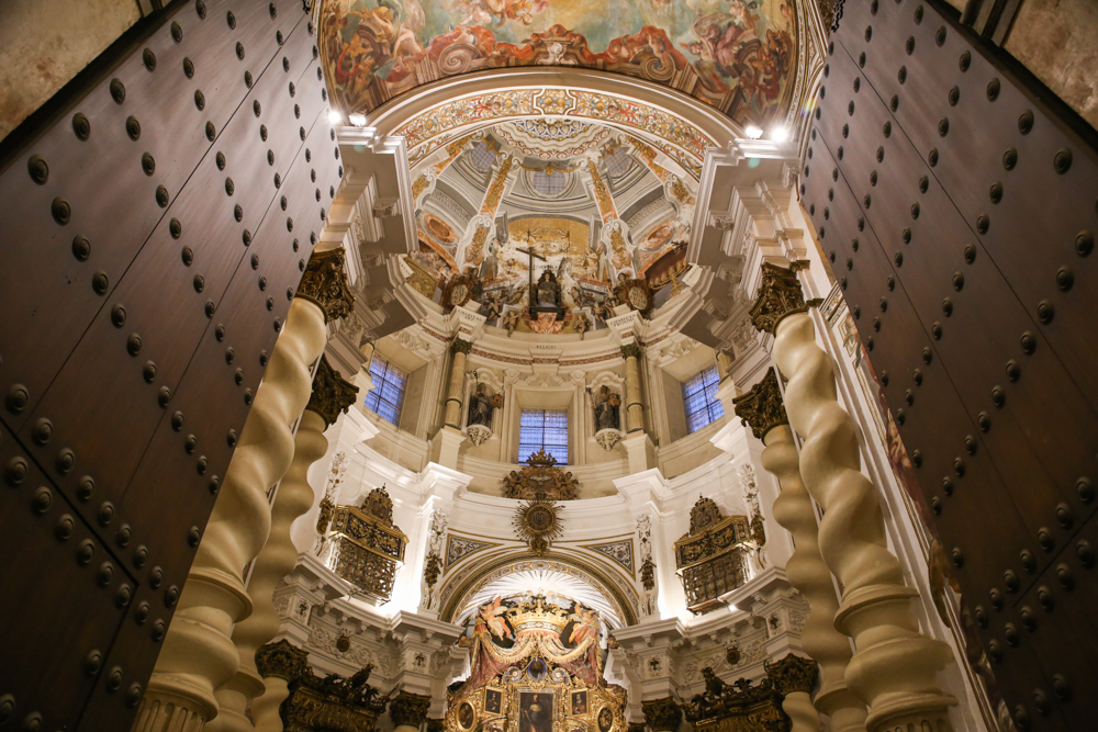 Ornate cathedral interior with tall columns and a painted dome.